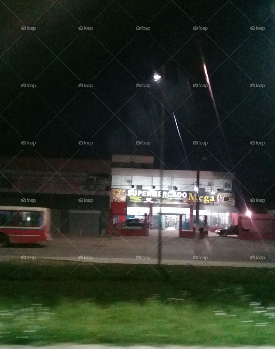 vista nocturna de un supermercado tomada desde un tren en movimiento