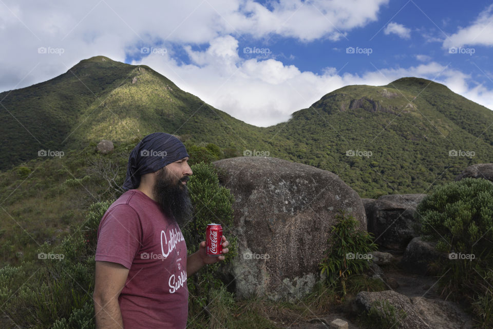 Man drinking Coca Cola on the mountain.