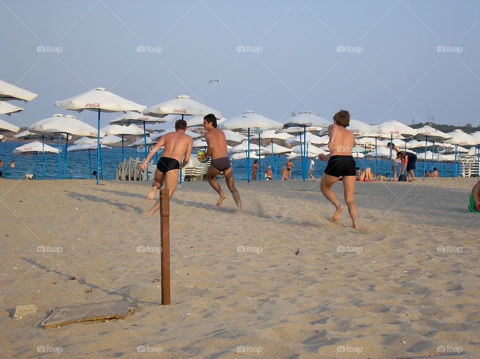 Boys playing football on the beach 