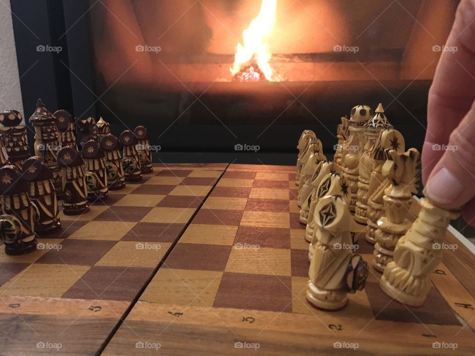 Preparing chessboard in front of fireplace 