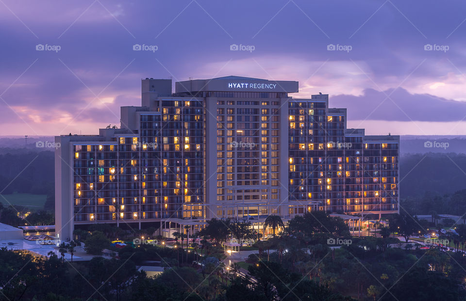 large, beautiful vacation resort building with golden window lights against a purple evening sky