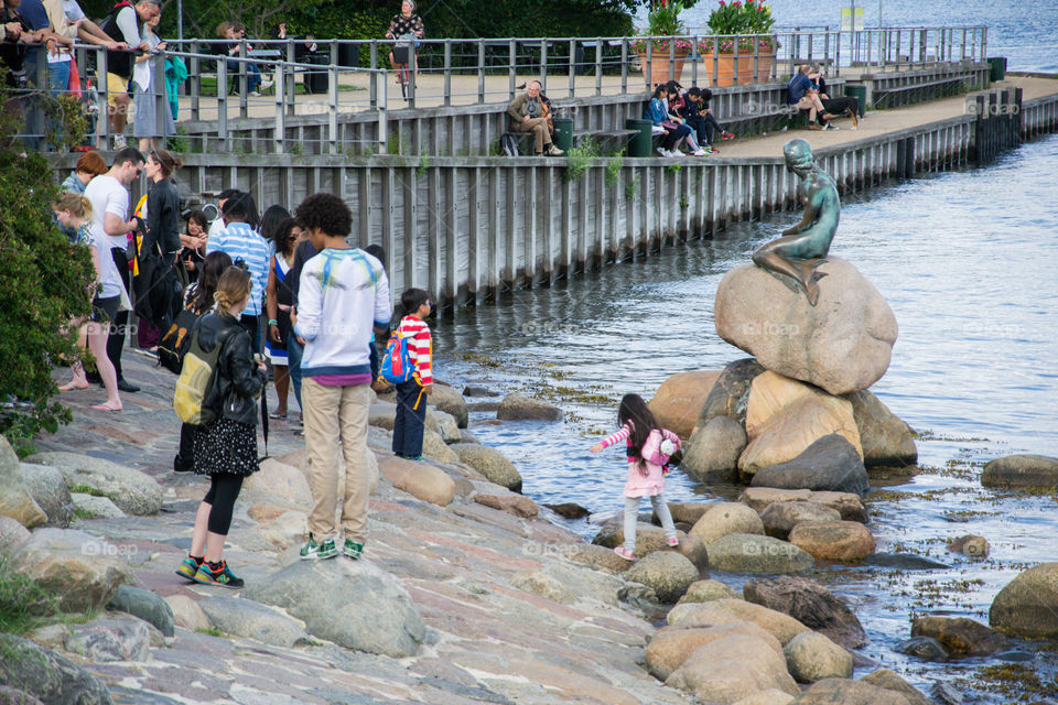 Tourist at the landmark the little meramid in Copenhagen in Denmark.