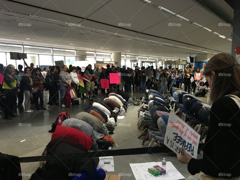 Protesters at SFO form a circle to protect a group of Muslims during the 4pm prayer 