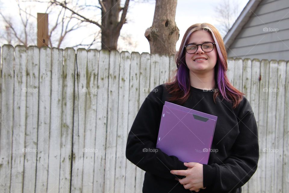 Teenager student with purple five star folder 