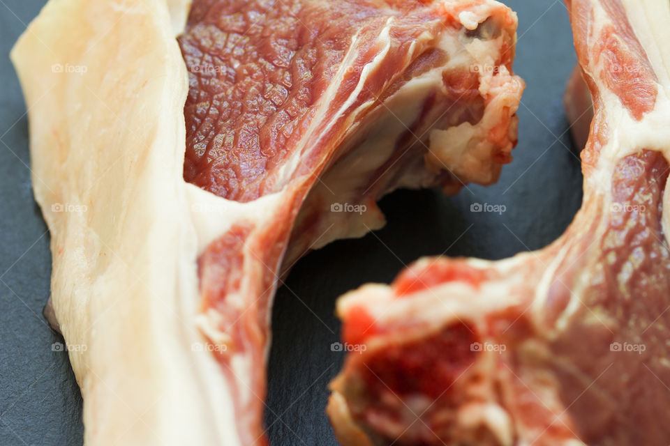 close up of raw lamb steaks on a stone board