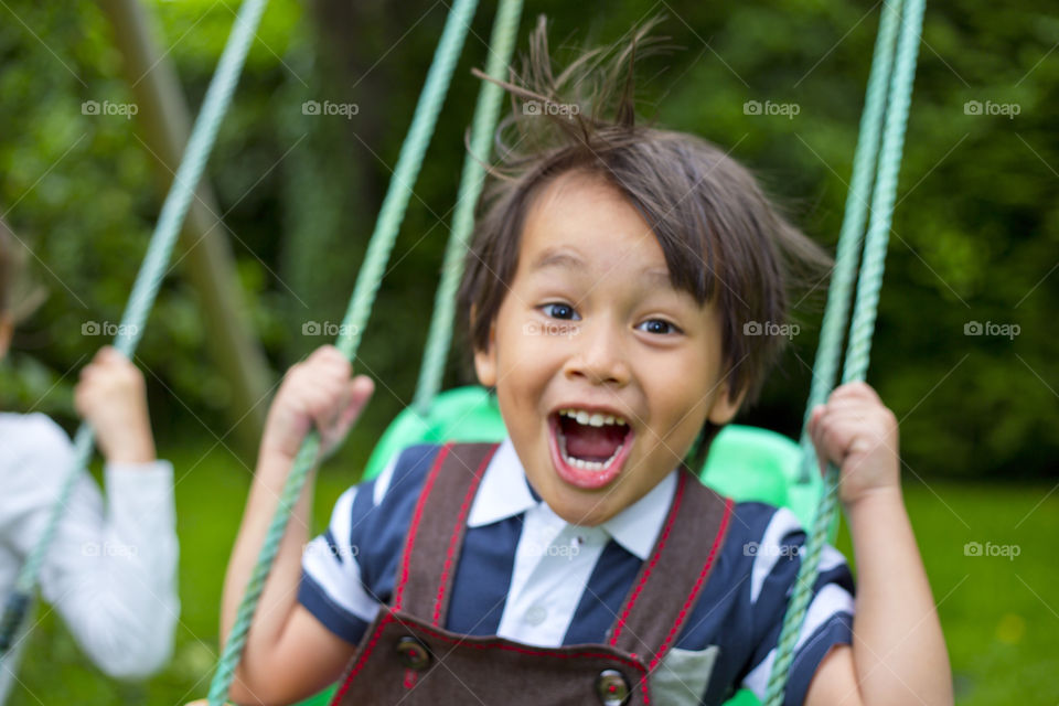 Young boy having fun . it's spring time and enjoy the swing