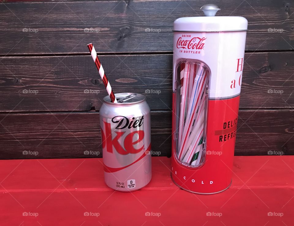 Diet Coke can with vintage straw dispenser. Wooden background. 