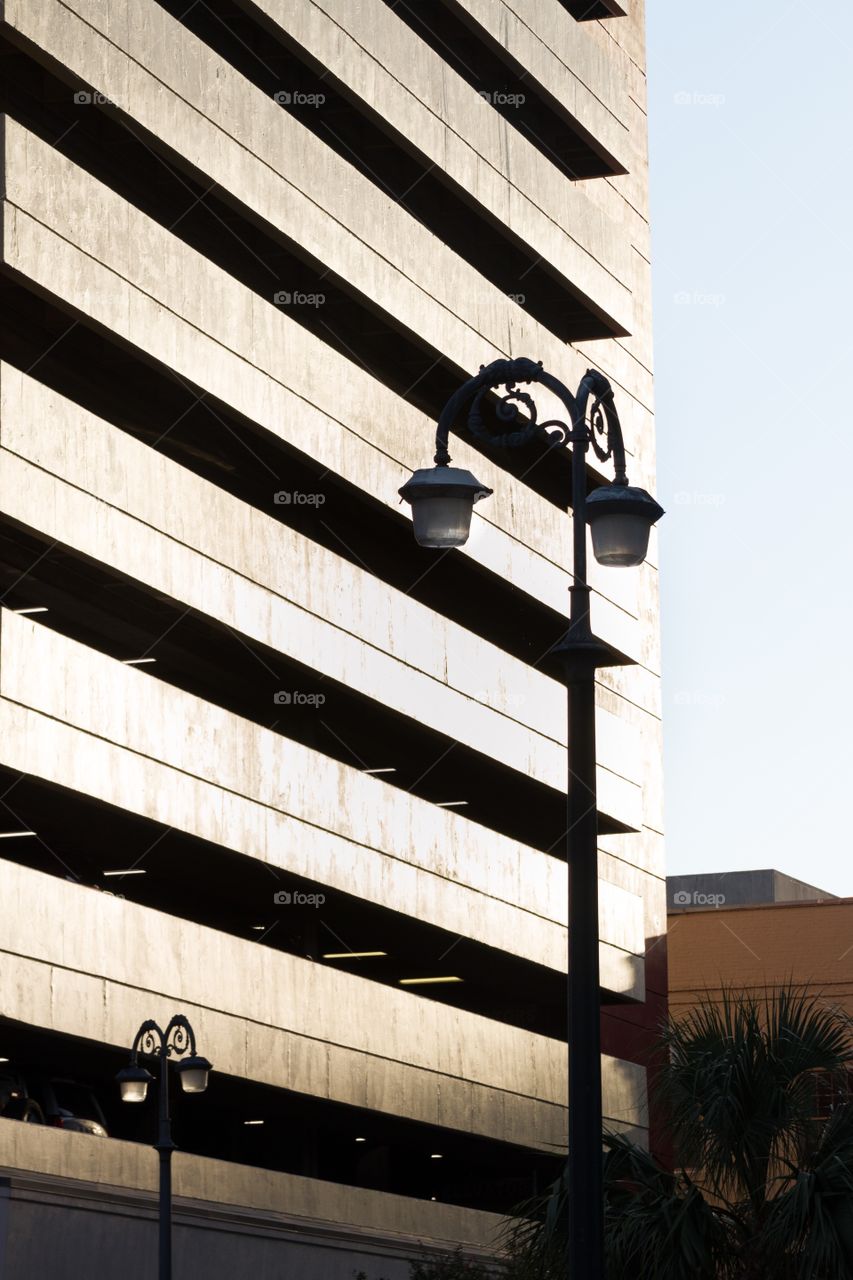 Building parking garage in sun with lamp post in New Orleans 
