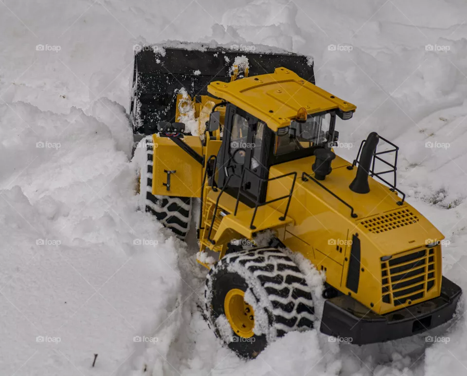 Remote control bulldozer pushing first snow of the season. 