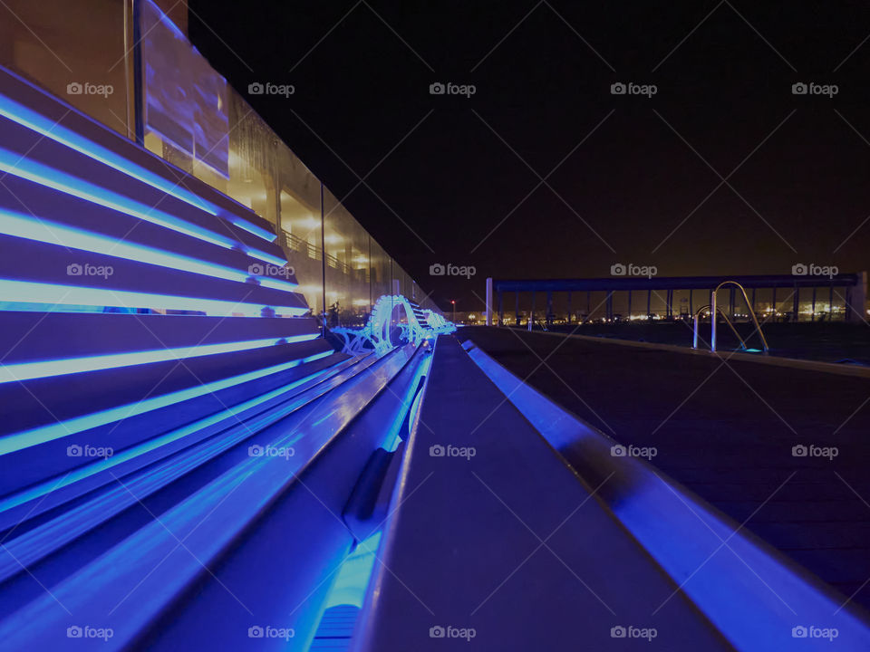 sitting bench, lit with blue led lights in the dead of night