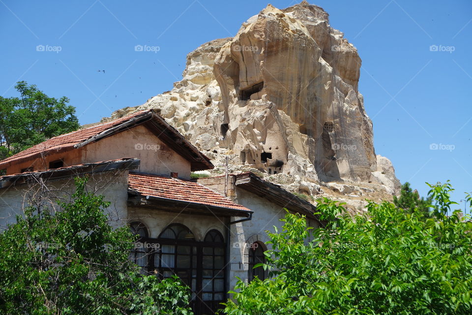 Natural formation volcanic rock and gorgeous wooden house and green trees