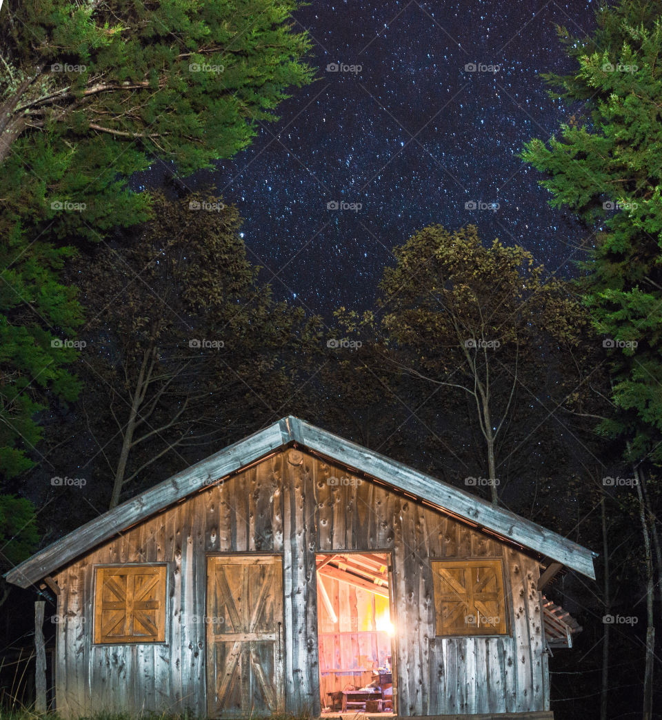 Beautiful view of the starry sky in the middle of the forest with a nice cabin