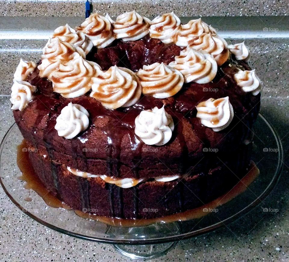 Homemade chocolate cake with vanilla cinnamon buttercream frosting topped with a caramel sauce, all from scratch