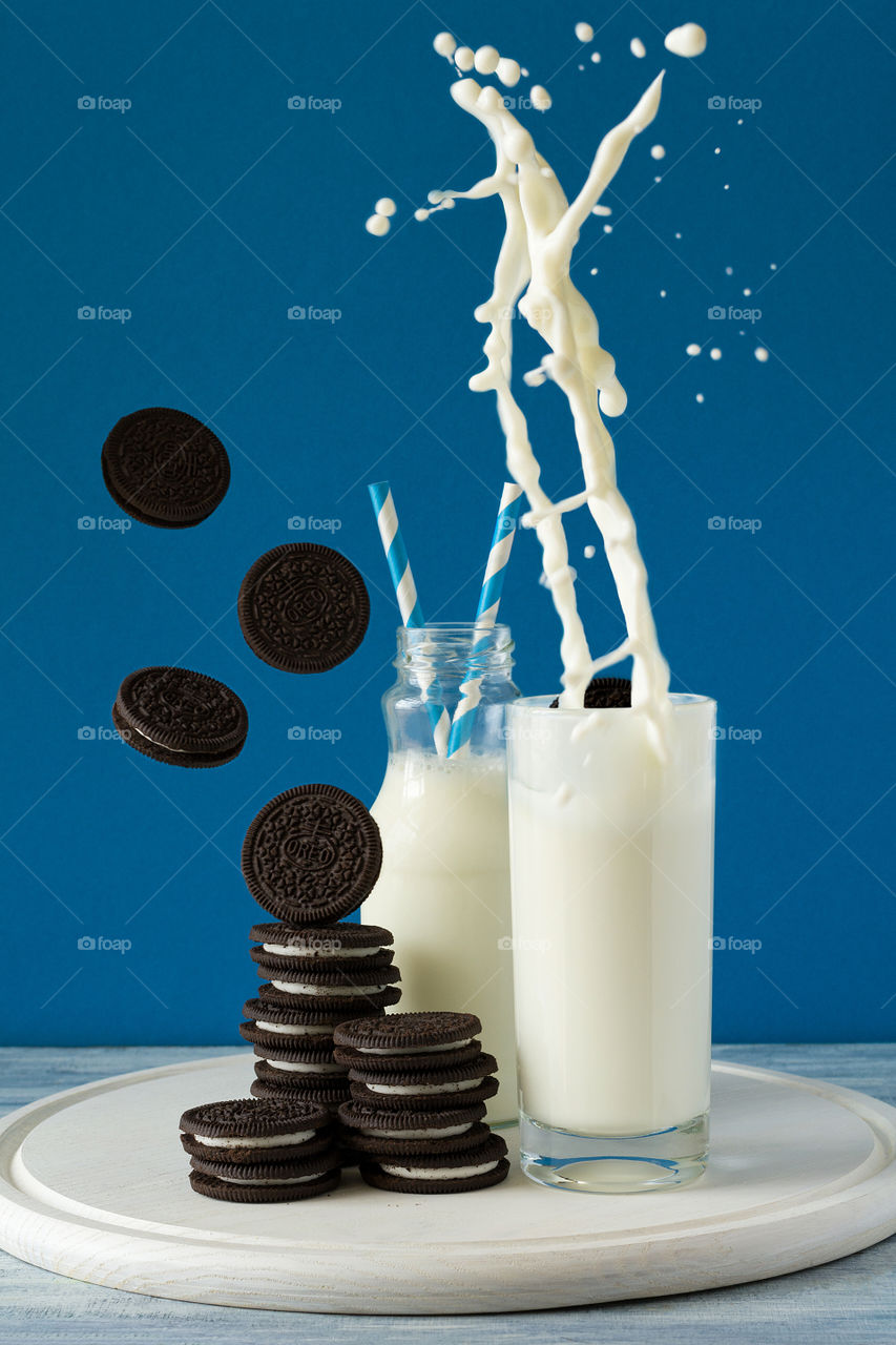 Oreo cookies and milk on blue background