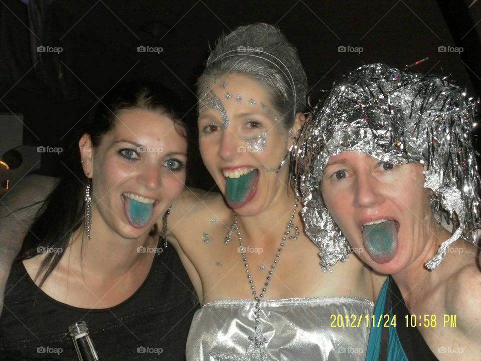 Portrait of female friends sticking out tongue