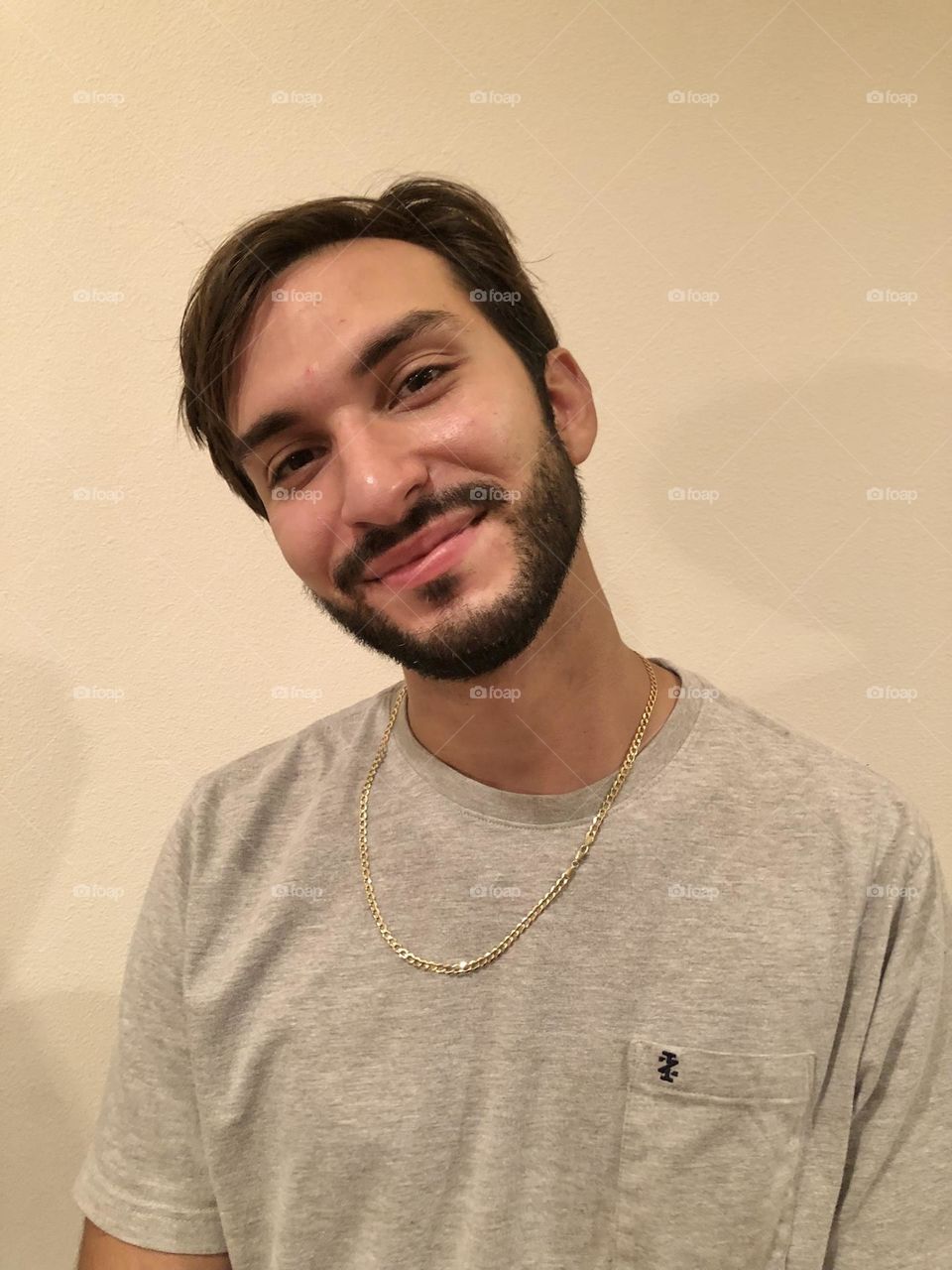 Young bearded man tilting head and smiling