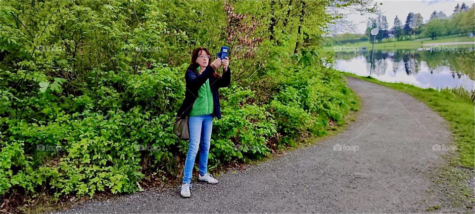 Taking pictures out in nature is fun. The lady in this picture knows this as she’s taking photos in the “Bayerischer Wald”, the “Bavarian Forest” near the township of “Eging” and the “Eging Lake”, the “Eginger See”. 2024. Hypnotic Productions
