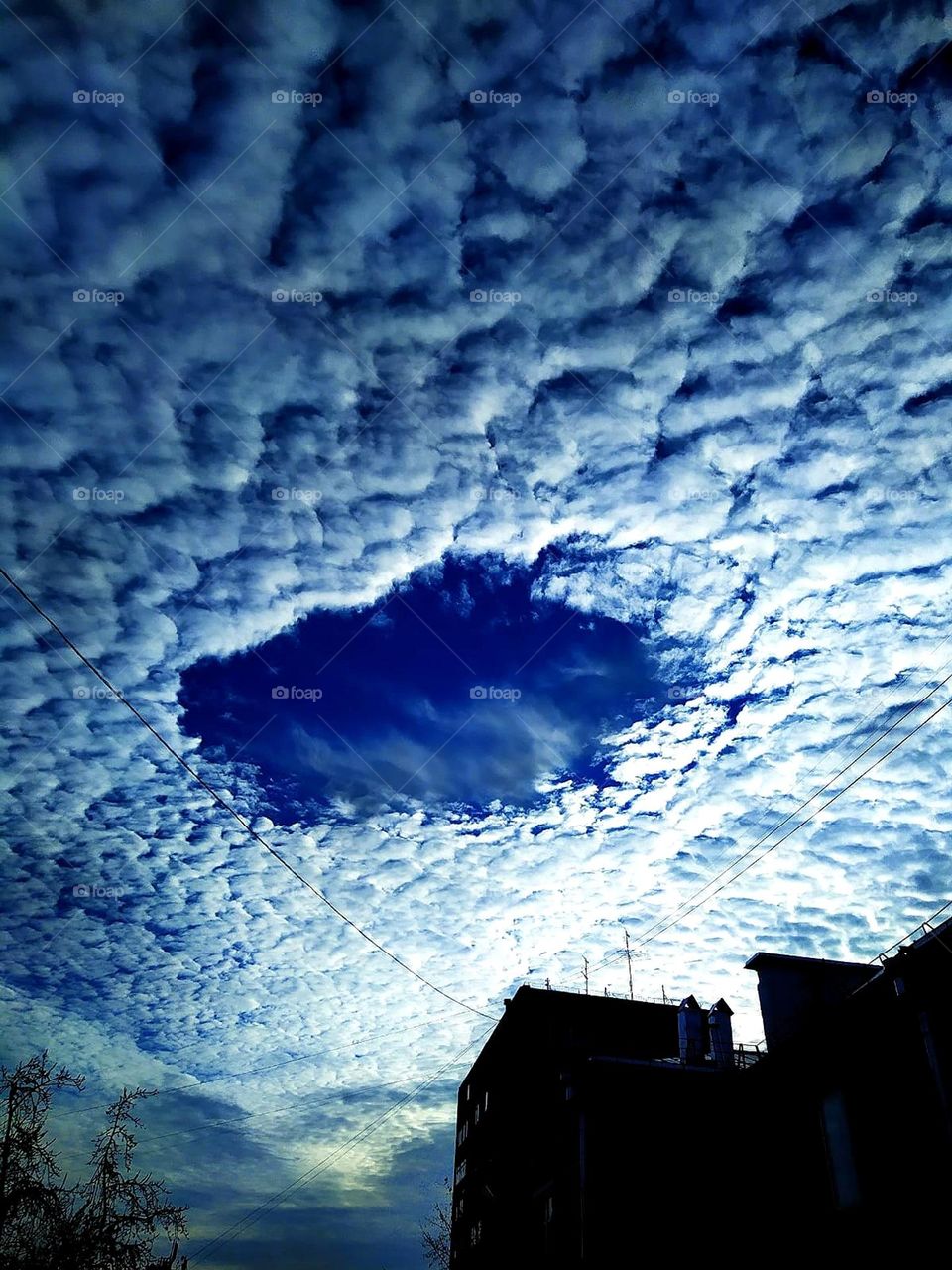 There is a huge cloud above the house with a round hole in it. Riddles in nature