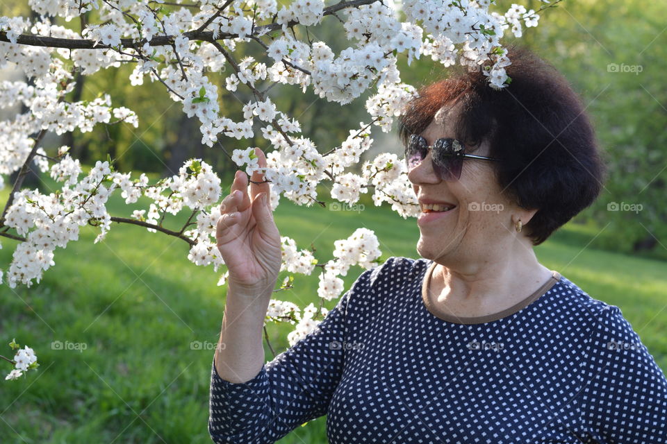 woman smiling spring blooming green background, emotions