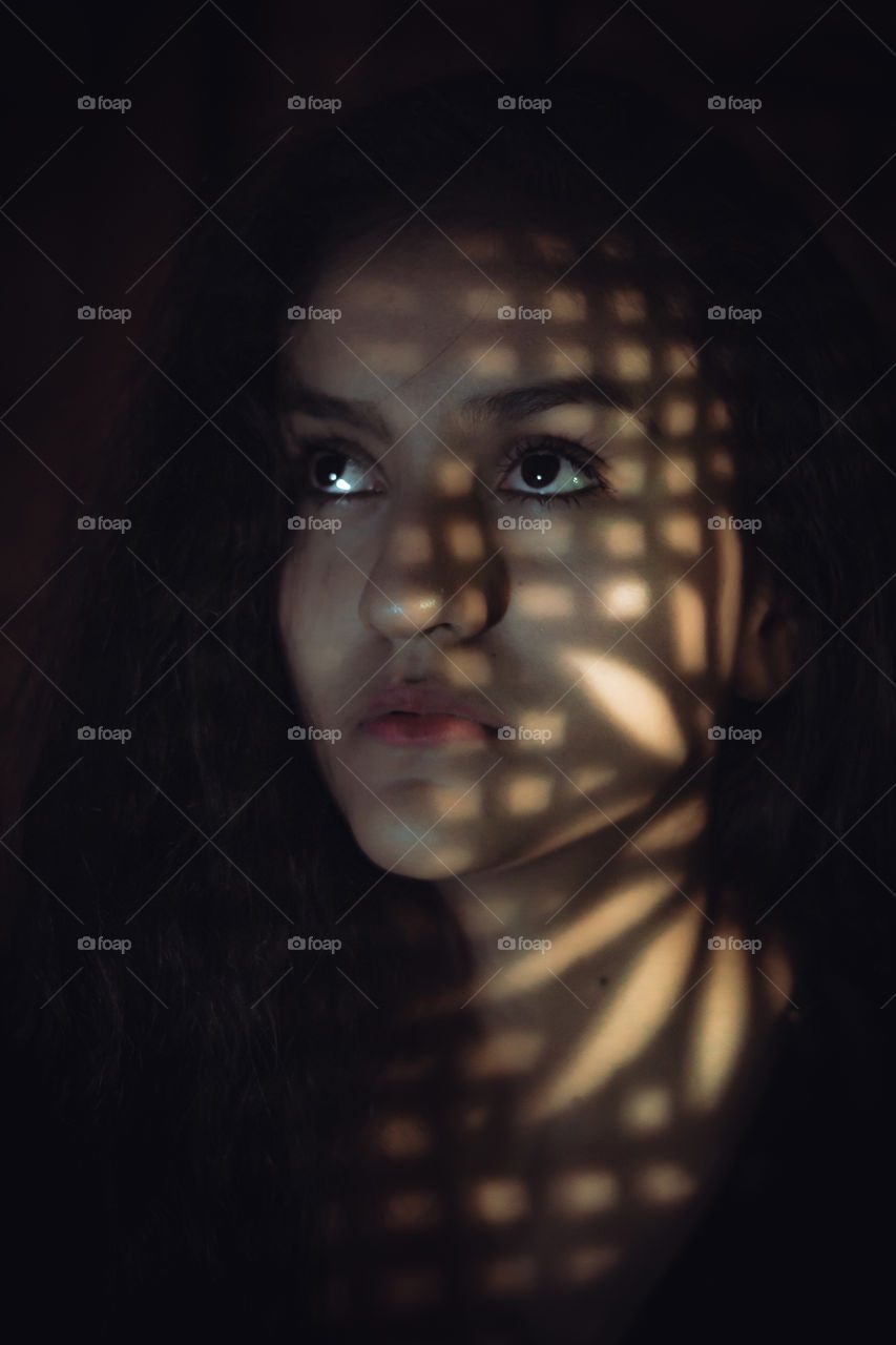 Illumination of lights and shadows, portraits of girl with dark background and shadows that are formed with a light source