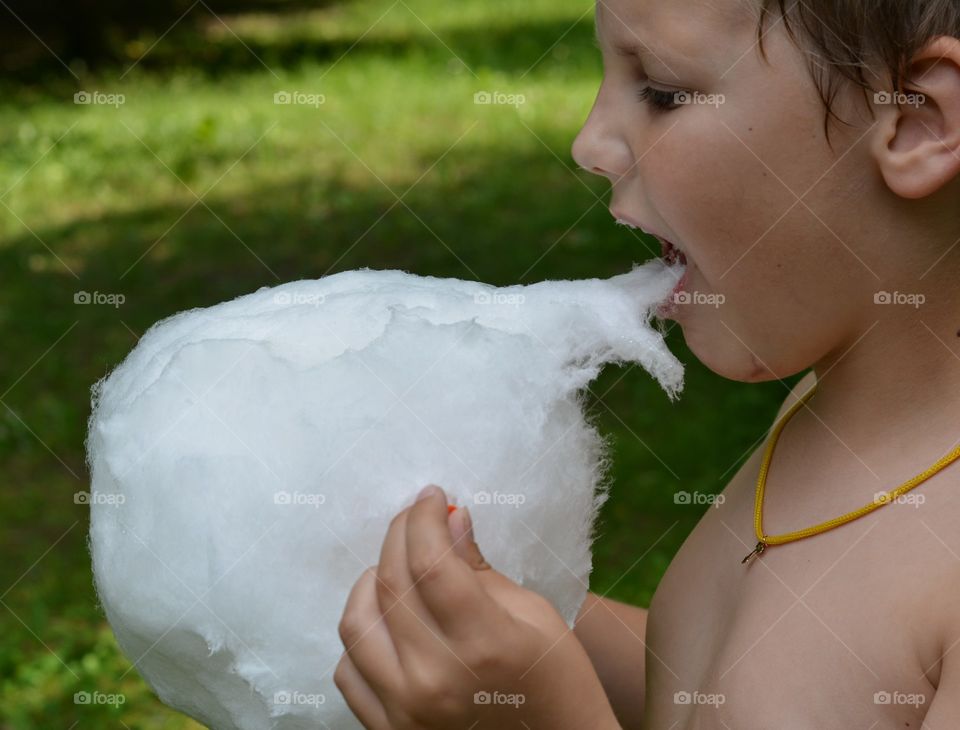 child eating sugar sweet in the park summer time