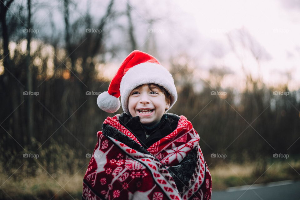 Little boy in Santa hat laughing 