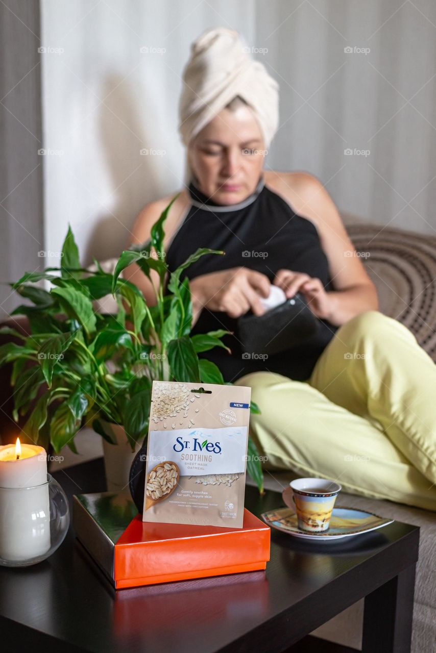 an aged woman uses her favorite cosmetics st. Ives after shower face mask at home