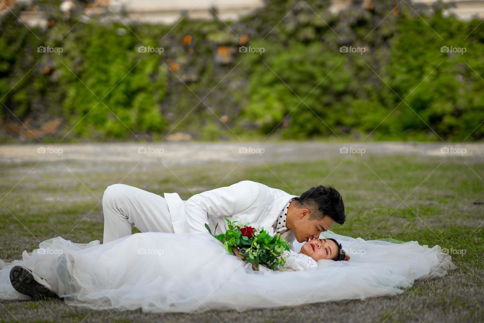 Couple in white kissing.