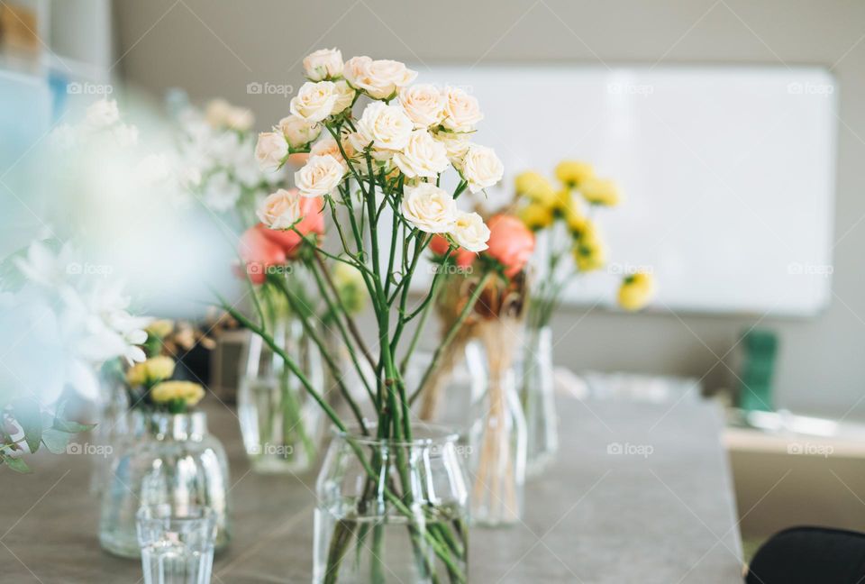 Bouquet of flowers roses in vase on table at home 