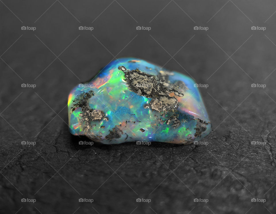 Photo of a beautiful black opal I hand formed and polished. This is a Ethiopian Opal on a black background 
