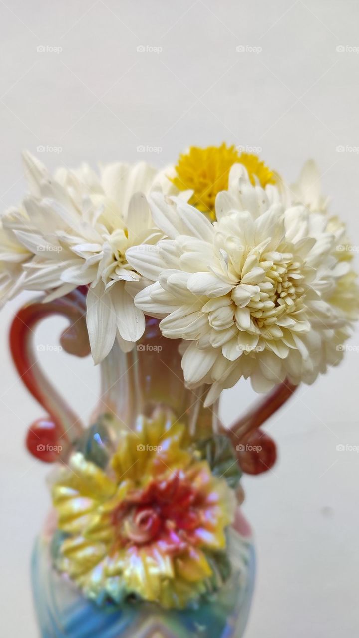 Beautiful white flowers in a colourful flowerpot with a flower sculpture, Flowers in a vase, colourful vase, white flowers in a vase
