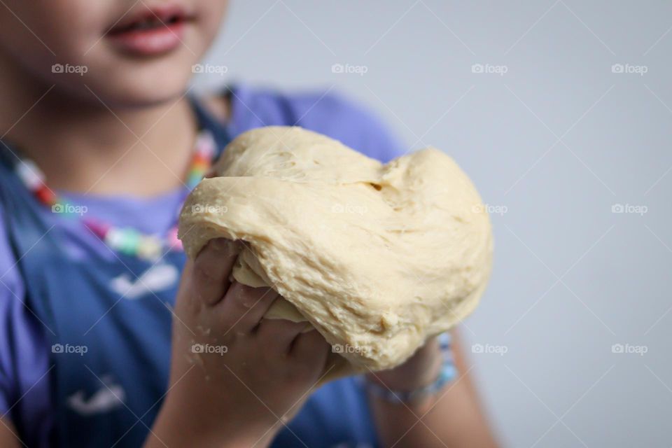 Cute child is helping to make bread at home