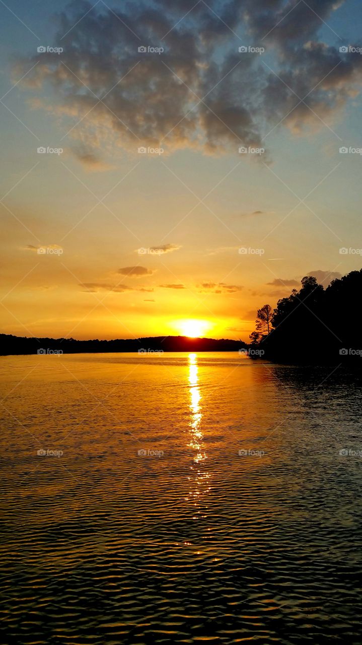 orange sunset with ripples on the lake.