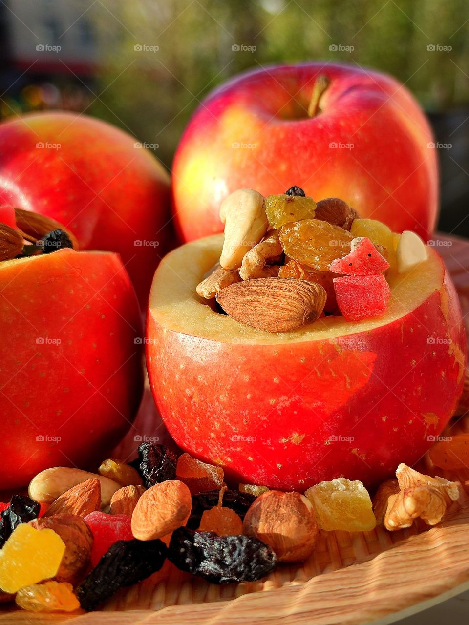 The color of the sun on a fruit composition.  Whole apples.  Apples with nuts and dried fruits inside