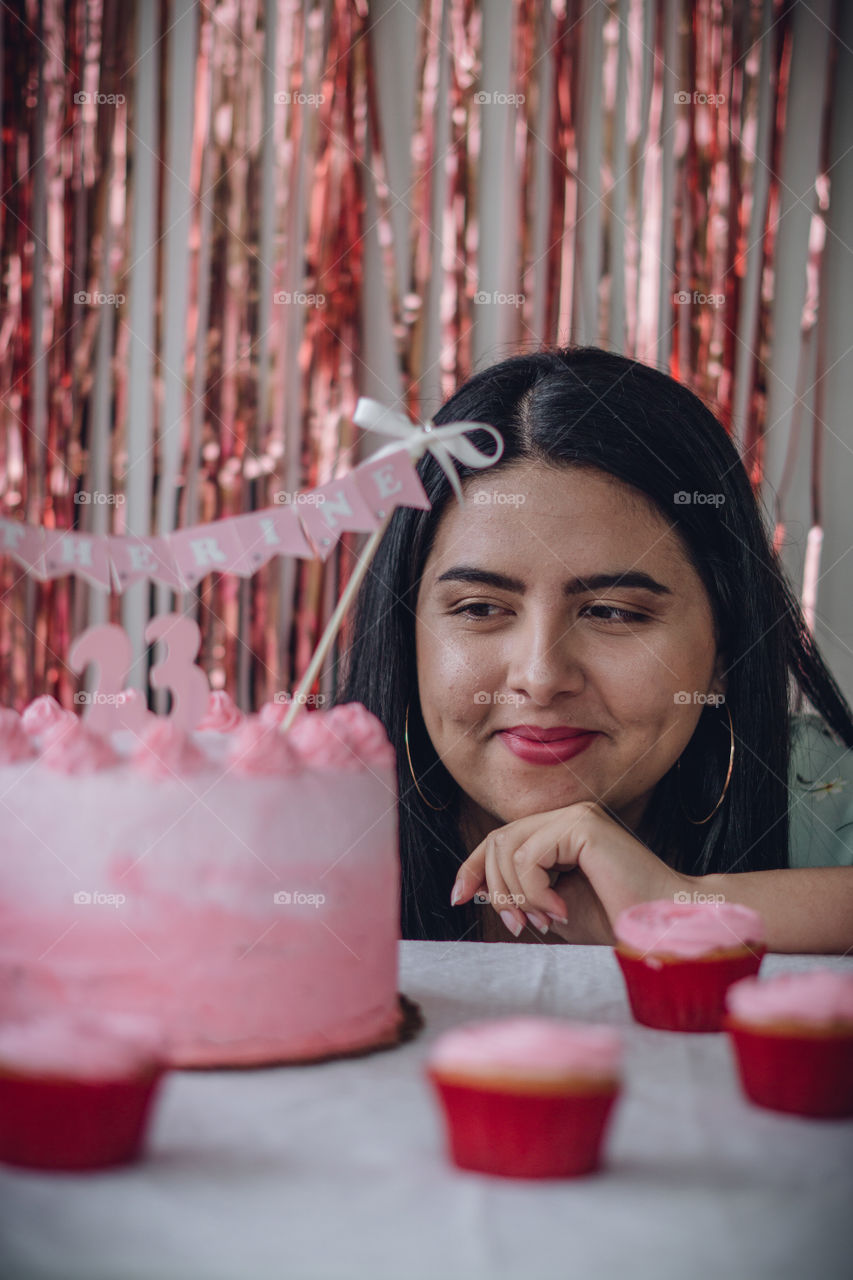 Girl watching her delicious birthday cake, girl in the middle of cupcakes and a cake