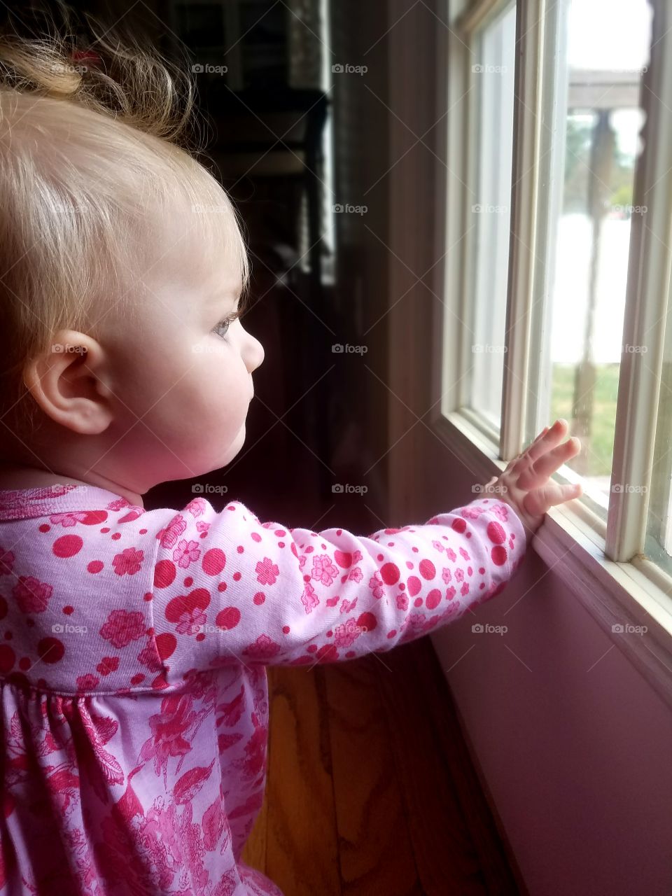 Little girl looking at window