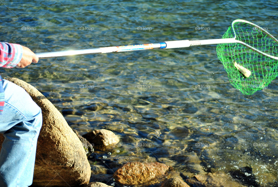 Man holding fishing rod for a Fresh catch of trout fish from the lake