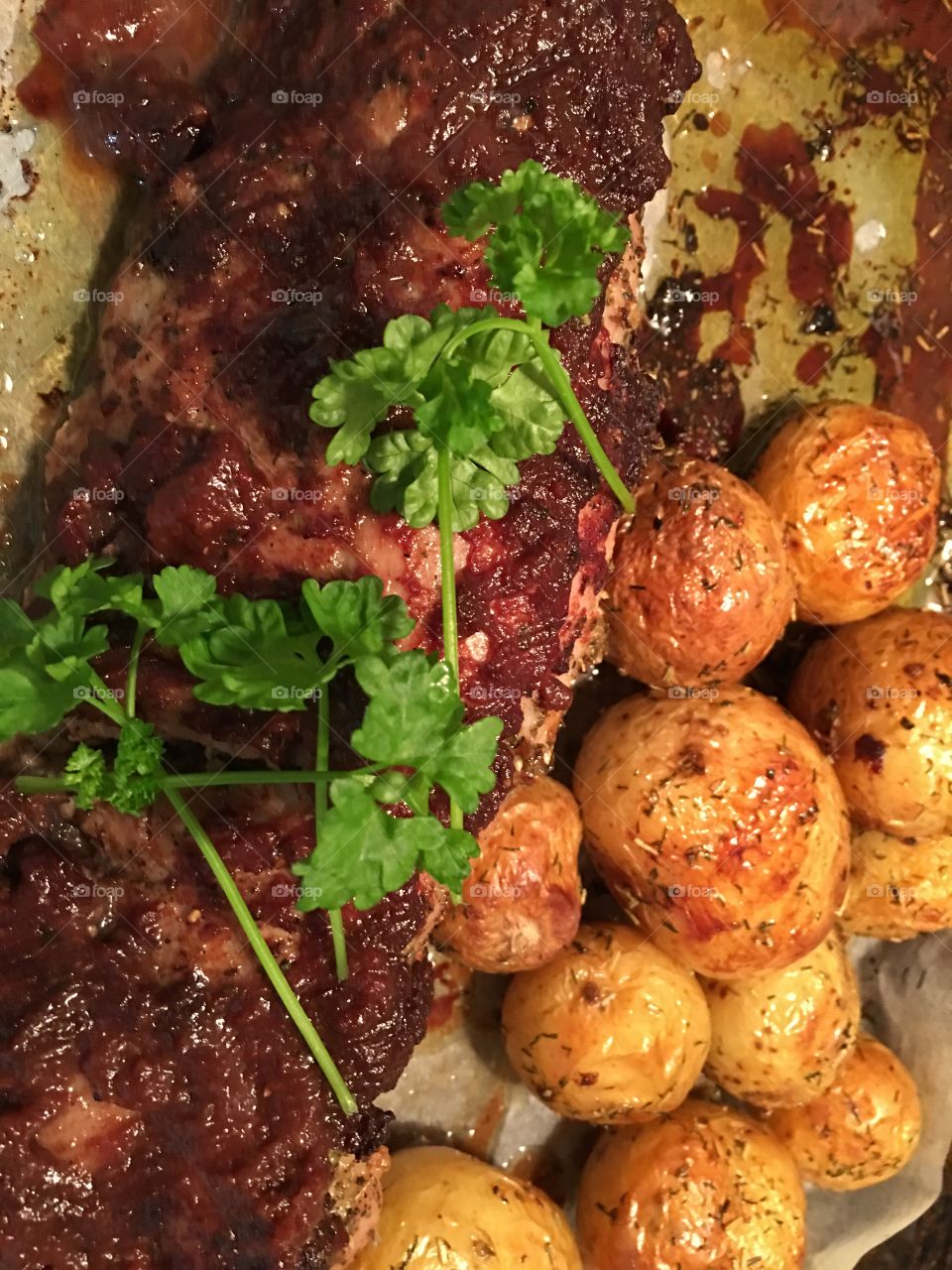 Roast pork tenderloin basted with homemade quince sauce, roasted white baby potatoes, traditional Sunday dinner supper