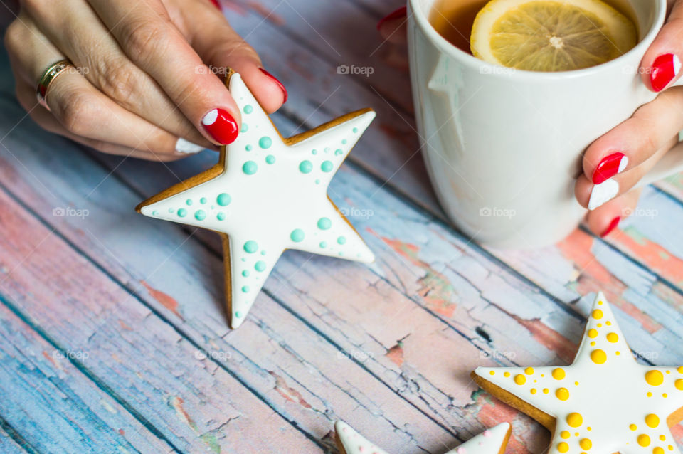 Woman hand with cup of tea and cookie