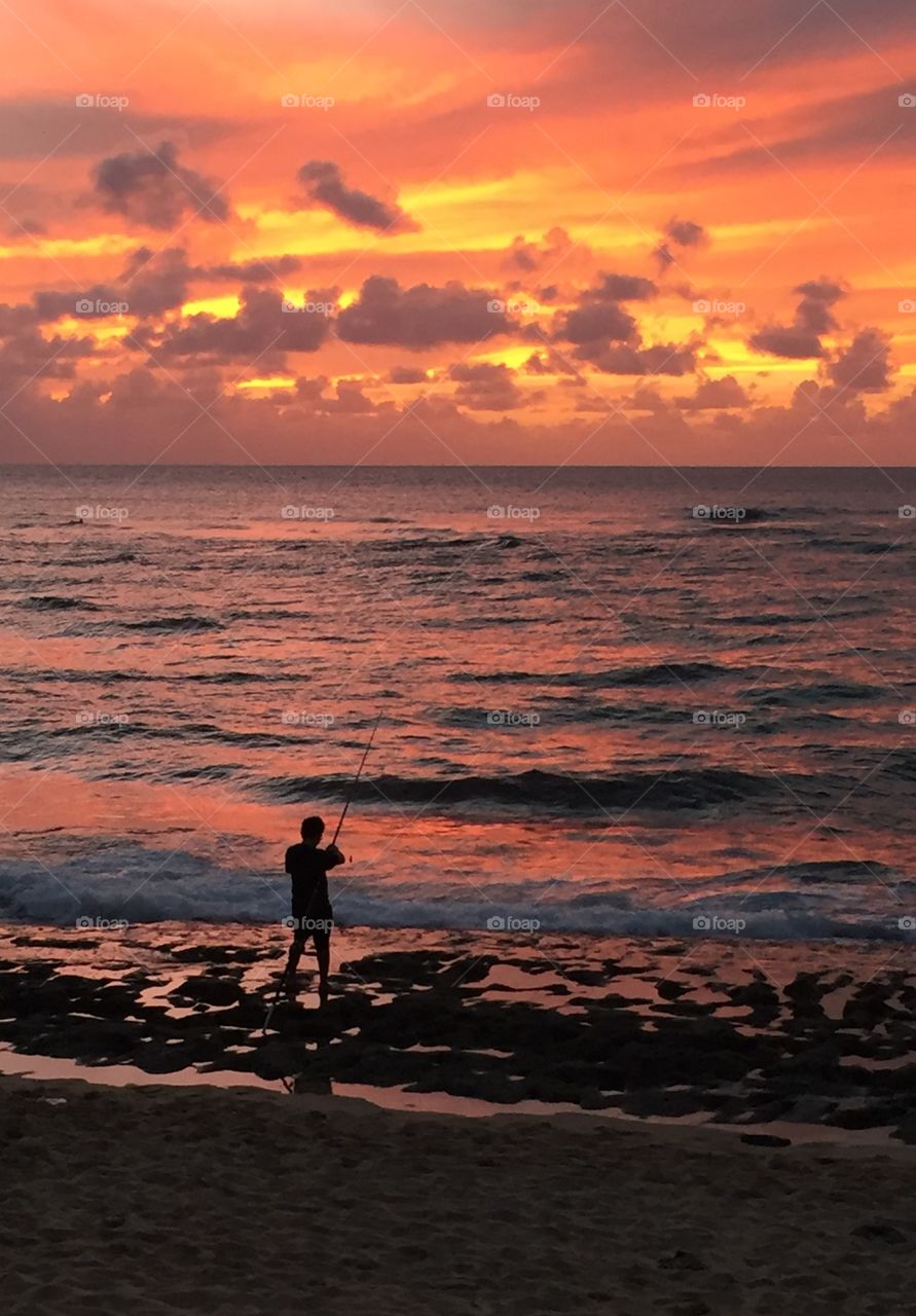 Fisherman at sunset at Laniakea Beach, Oahu, Hawaii