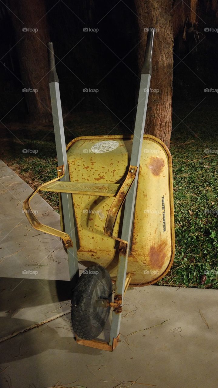 yellow wheelbarrow rusted