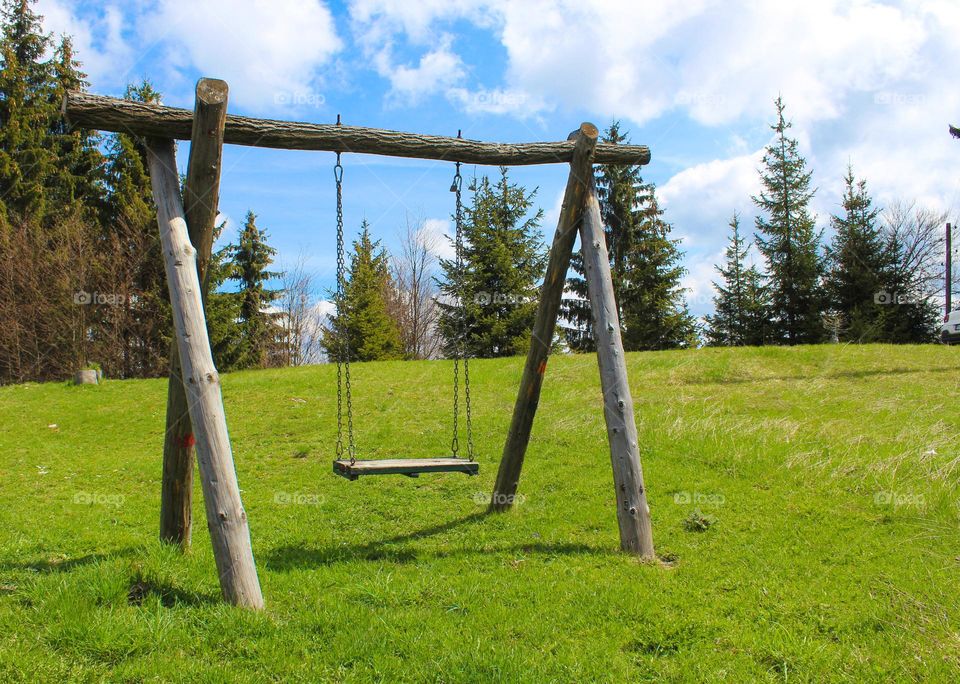 Spring landscape.  Wooden swing in a natural environment