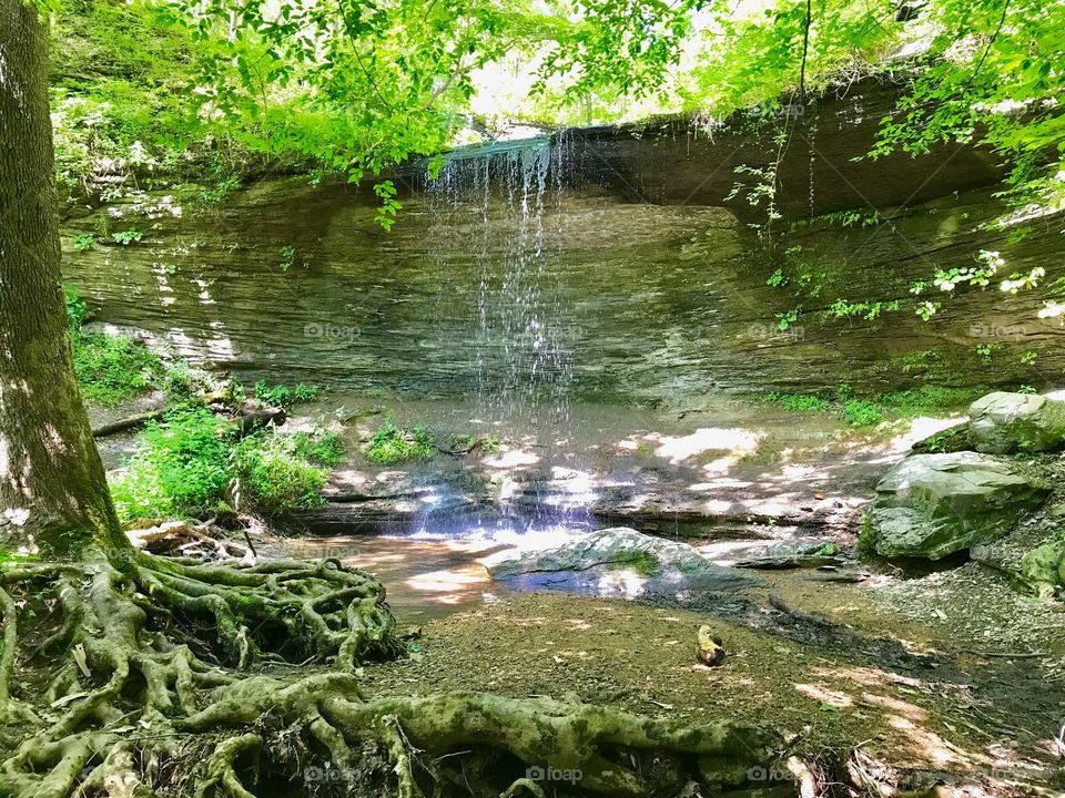 Sun reflects off the bottom of a waterfall