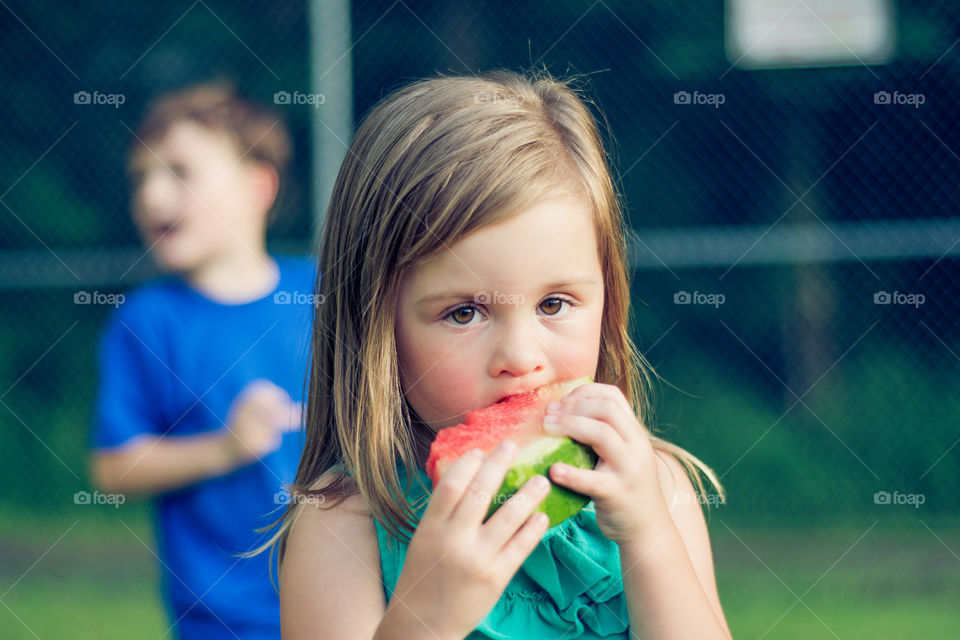 Young Girl Eating Watermelon Outside at Park 5