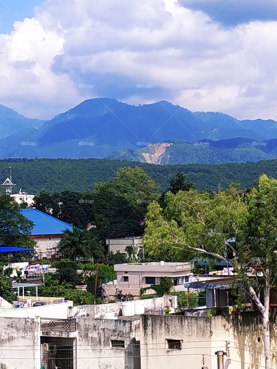 Beautiful autumn afternoon in the Himalayan  foothills. Beautiful Mussoorie hills on the backdrop with residual monsoon clouds in the sky