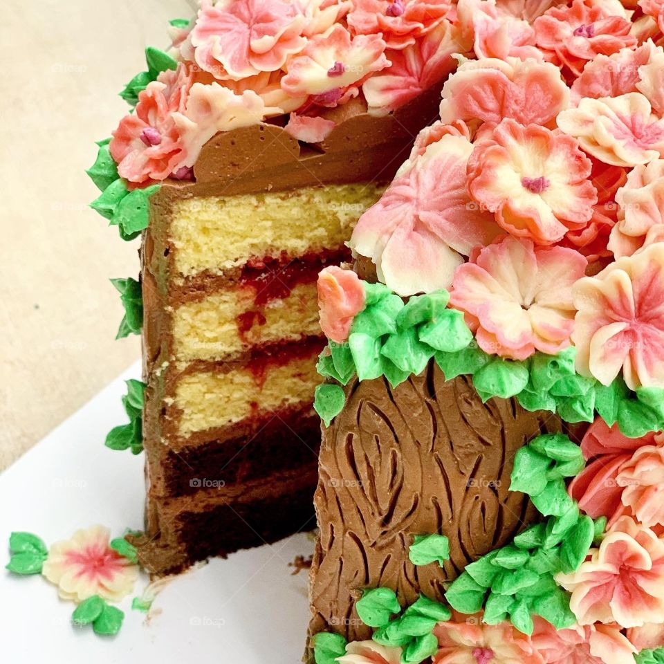 Homebake gorgeous 3D pink log edible floral buttercream cake with chocolate and vanilla and strawberry fillings sliced up