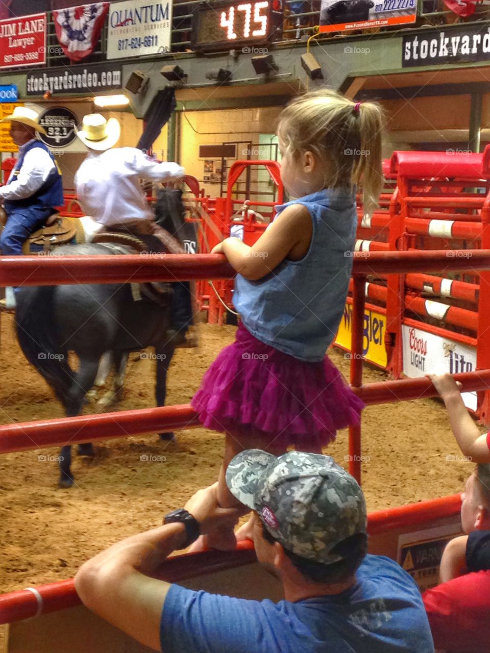 I wanna ride, daddy. Girl watching Cowboys ride horse at a rodeo