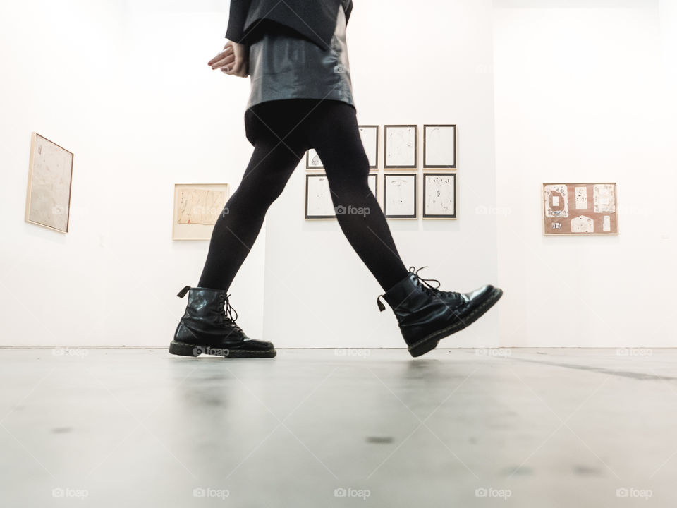 contemporary art museum with bottom view on woman legs walking on the hall