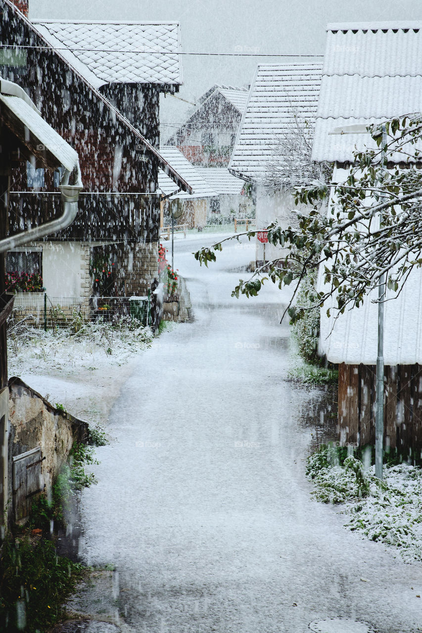 View of snowfall over the slovenian village and snow-covered trees and road in winter