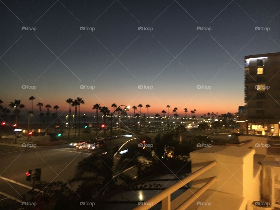 Sunset on hotel balcony in Huntington Beach. Chill vibe. Easy Friday night. Soothing ocean sounds and inviting chatter and laughter from local spots